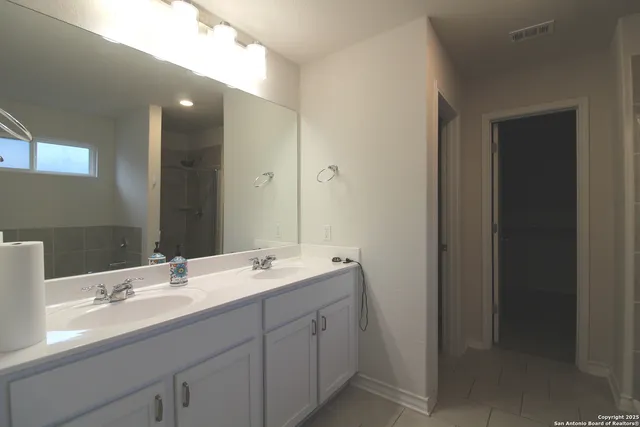 a bathroom with a double vanity sink and mirror