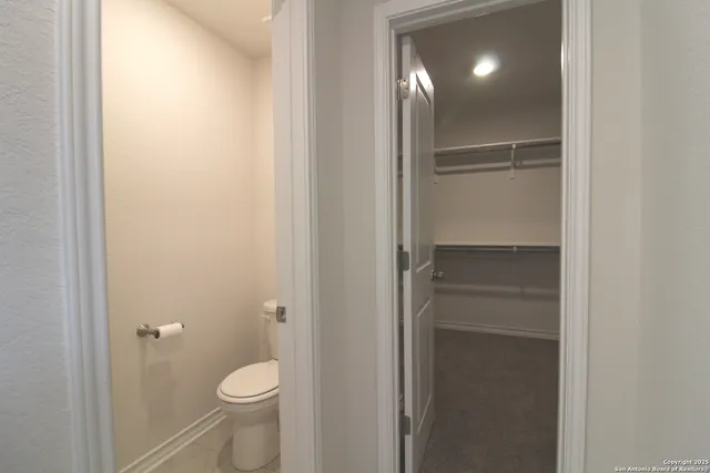 a bathroom with a granite countertop toilet and a shower