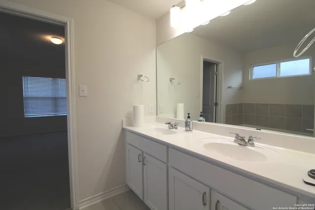 a bathroom with a double vanity sink and a mirror