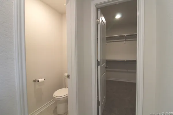 a bathroom with a granite countertop toilet and a shower