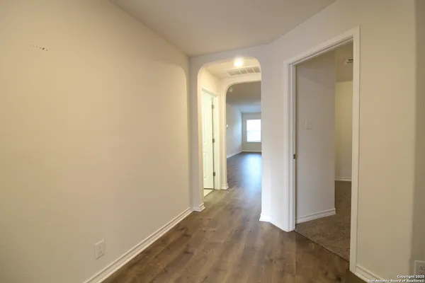 an empty room with wooden floor and a bathroom