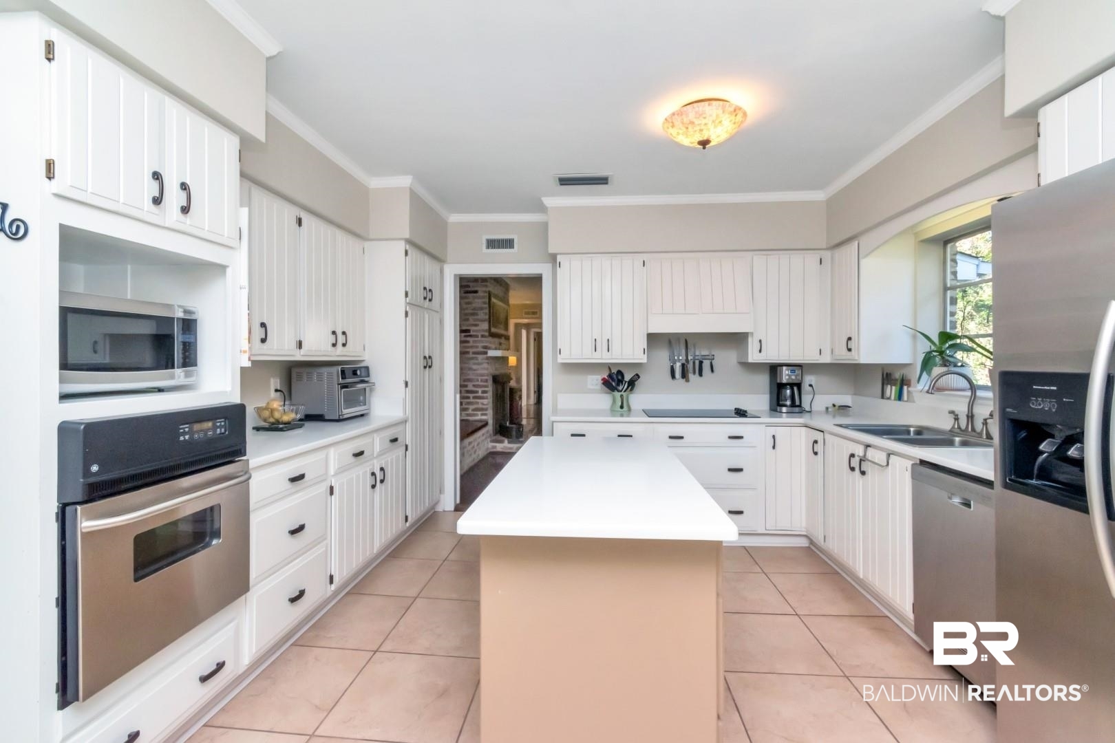 302 Springwood Drive East Mobile, AL 36608 - Photo 16 of 35 Kitchen featuring crown molding, sink, a kitchen island, white cabinetry, and stainless steel appliances