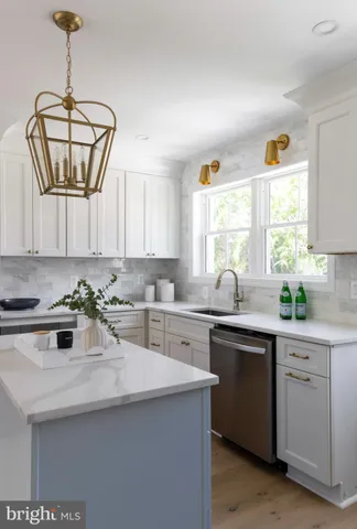 a kitchen with a sink a window stainless steel appliances and cabinets