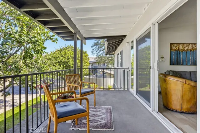 a balcony with wooden floor and outdoor seating