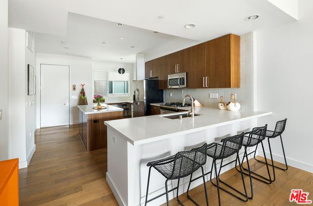 a kitchen with a table chairs microwave and cabinets