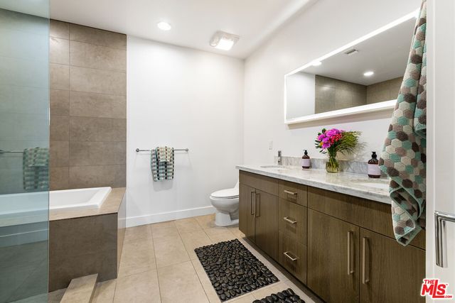a bathroom with a double vanity sink mirror and toilet