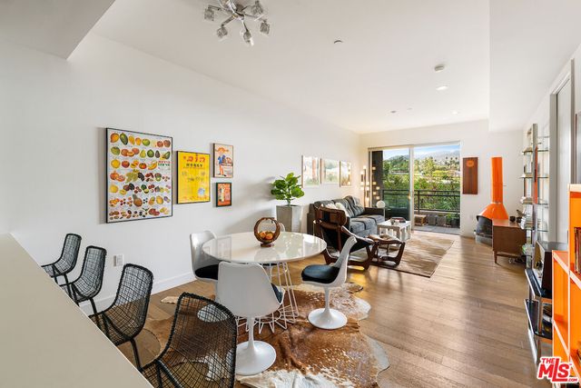 a dining room with furniture a large window and wooden floor