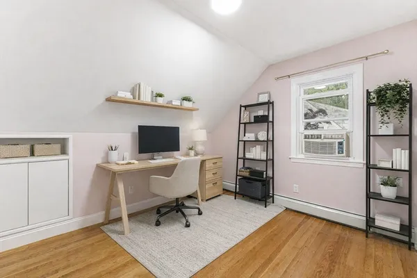 a workspace with wooden floor and a window