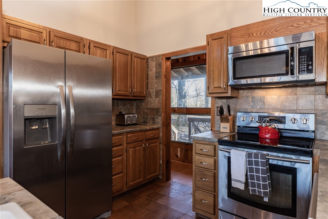 107 Buckshot Ridge Road Deep Gap, NC 28618 - Photo 17 of 30 a kitchen with stainless steel appliances granite countertop a refrigerator and a stove top oven