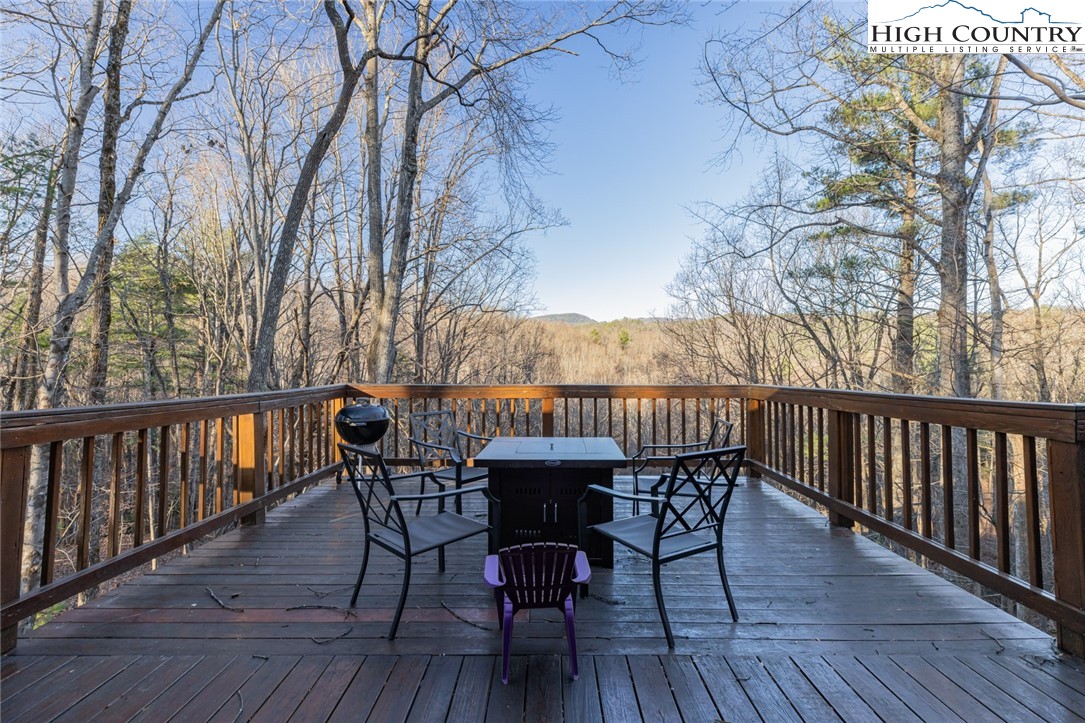 107 Buckshot Ridge Road Deep Gap, NC 28618 - Photo 2 of 30 a view of a deck with table and chairs and wooden floor