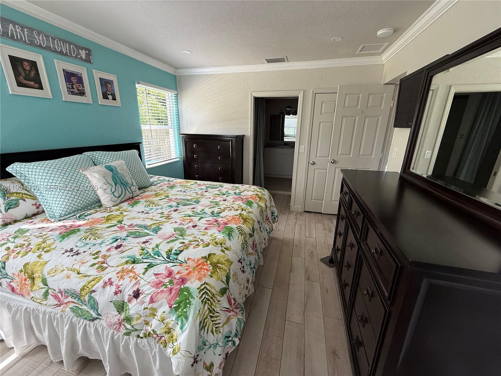 9546 Southwest Adams Avenue Okeechobee, FL 34974 - Photo 8 of 16 a bedroom with a bed and dresser