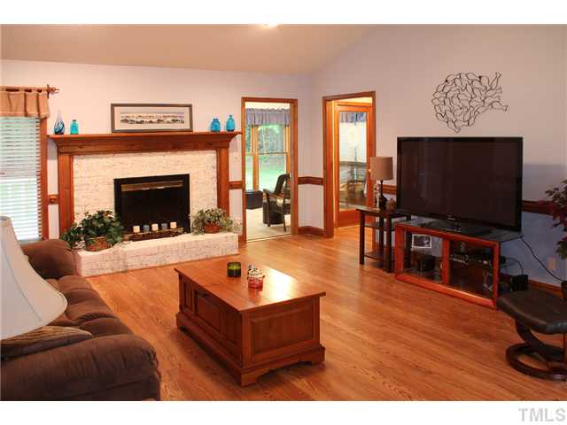 2025 Lovdal Drive Raleigh, NC 27613 - Photo 6 of 15 a living room with furniture a flat screen tv and a fireplace