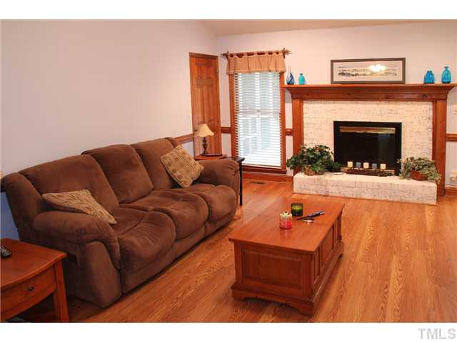 2025 Lovdal Drive Raleigh, NC 27613 - Photo 7 of 15 a living room with furniture a fireplace and a flat screen tv