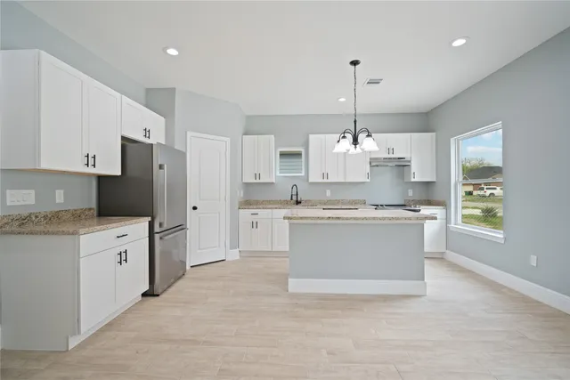 a large kitchen with kitchen island a sink stainless steel appliances and cabinets