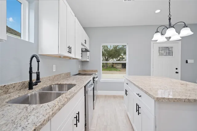 a kitchen that has a sink a stove and window