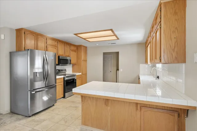 a kitchen with stainless steel appliances a refrigerator and a stove top oven