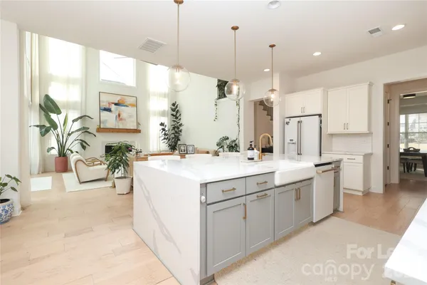 a large white kitchen with a large window a sink and a large window