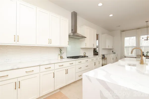 a kitchen with white cabinets appliances and a sink