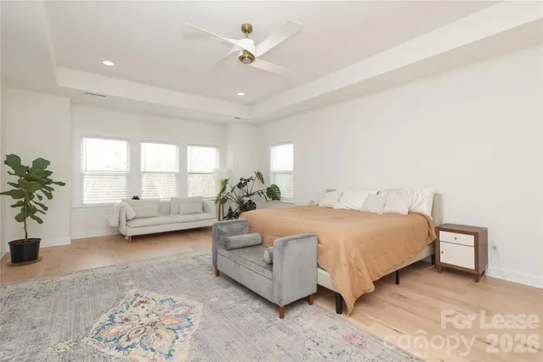 a spacious bedroom with a bed a couch and potted plant