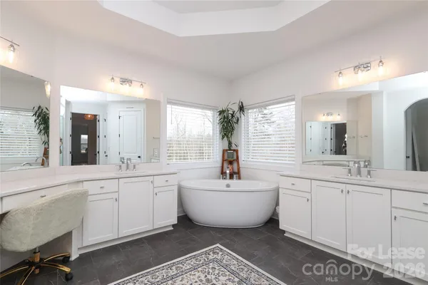 a spacious bathroom with a double vanity sink mirror and bathtub