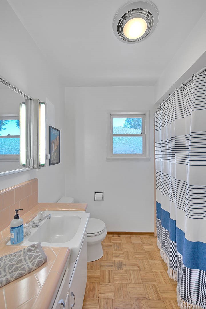 4845 Granada Avenue Riverside, CA 92504 - Photo 22 of 56 a bathroom with a granite countertop sink a toilet and mirror