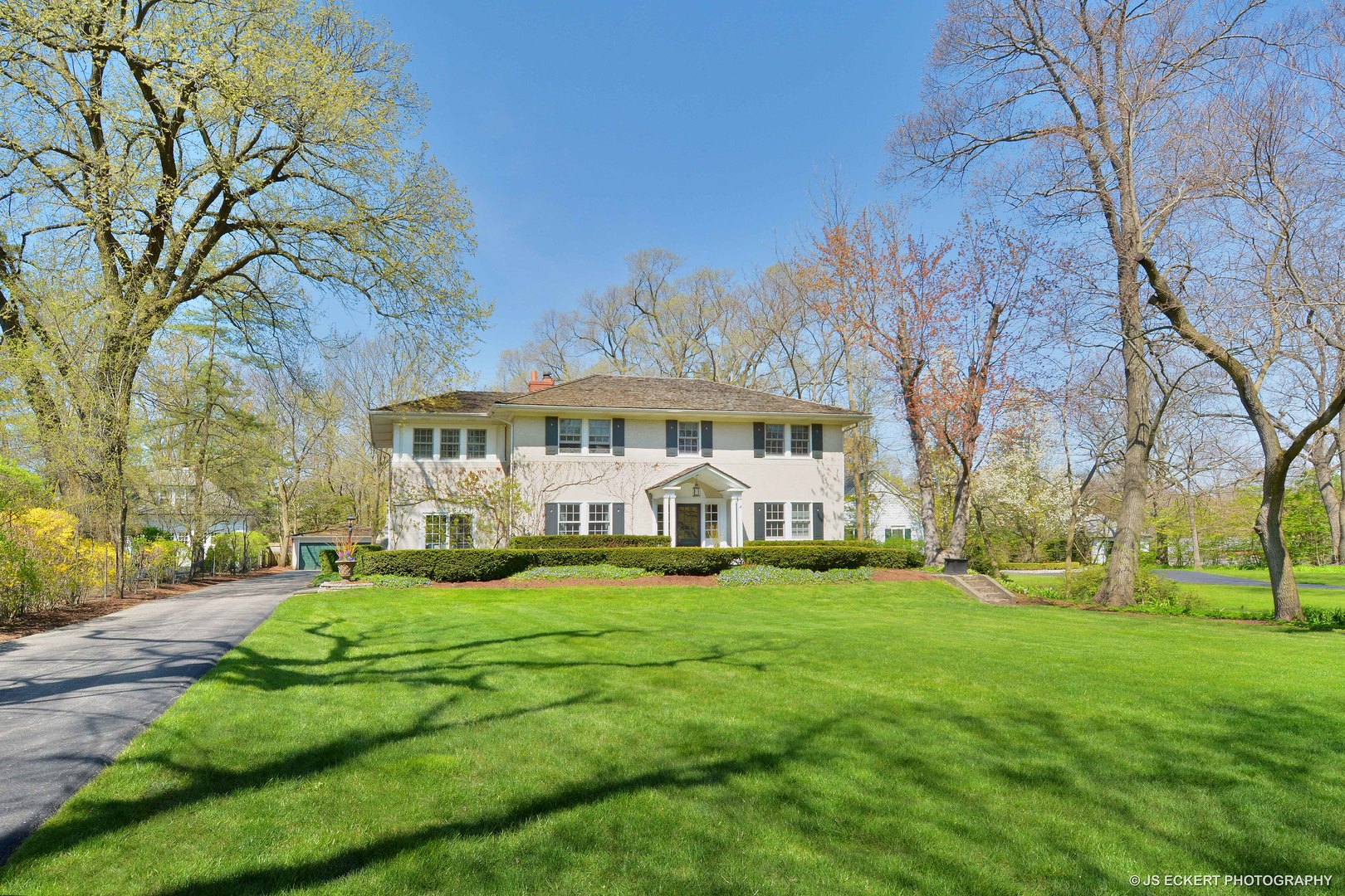 a view of a building with a big yard and large trees