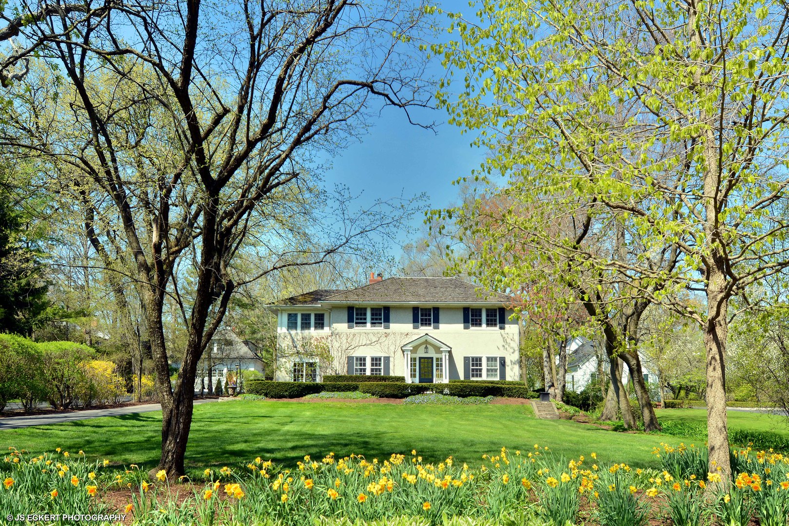 580 Washington Road Lake Forest, IL 60045 - Photo 3 of 46 a view of a white house with a big yard and potted plants and large trees
