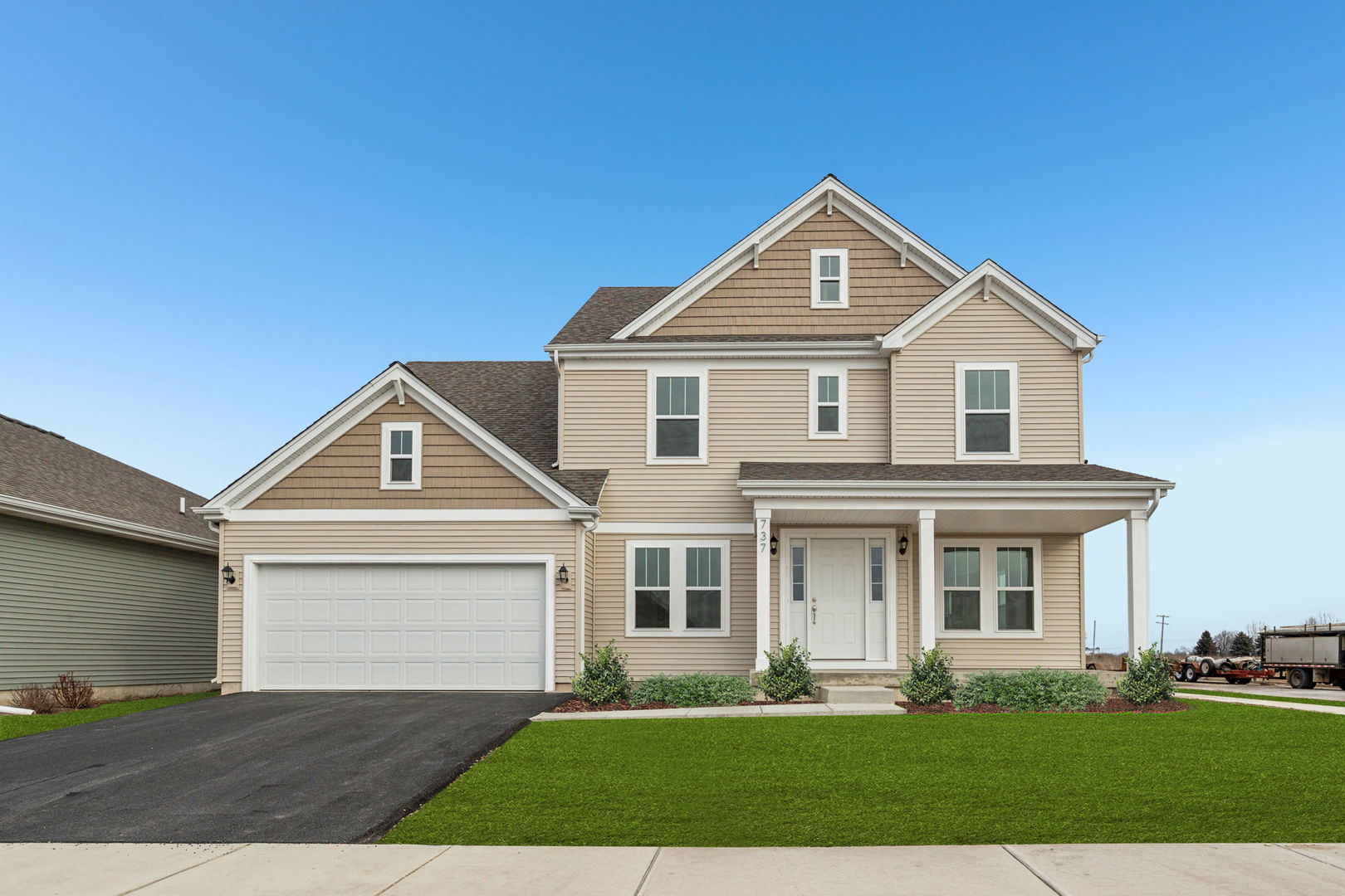 a front view of a house with a yard and trees