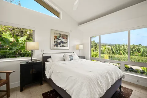 a large bed sitting in a bedroom next to a window