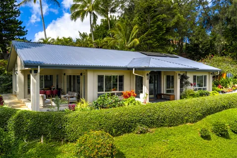 a front view of a house with garden and porch
