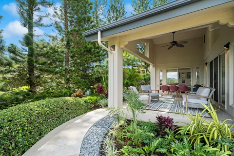 a view of a patio with table and chairs potted plants with floor to ceiling window and potted plants