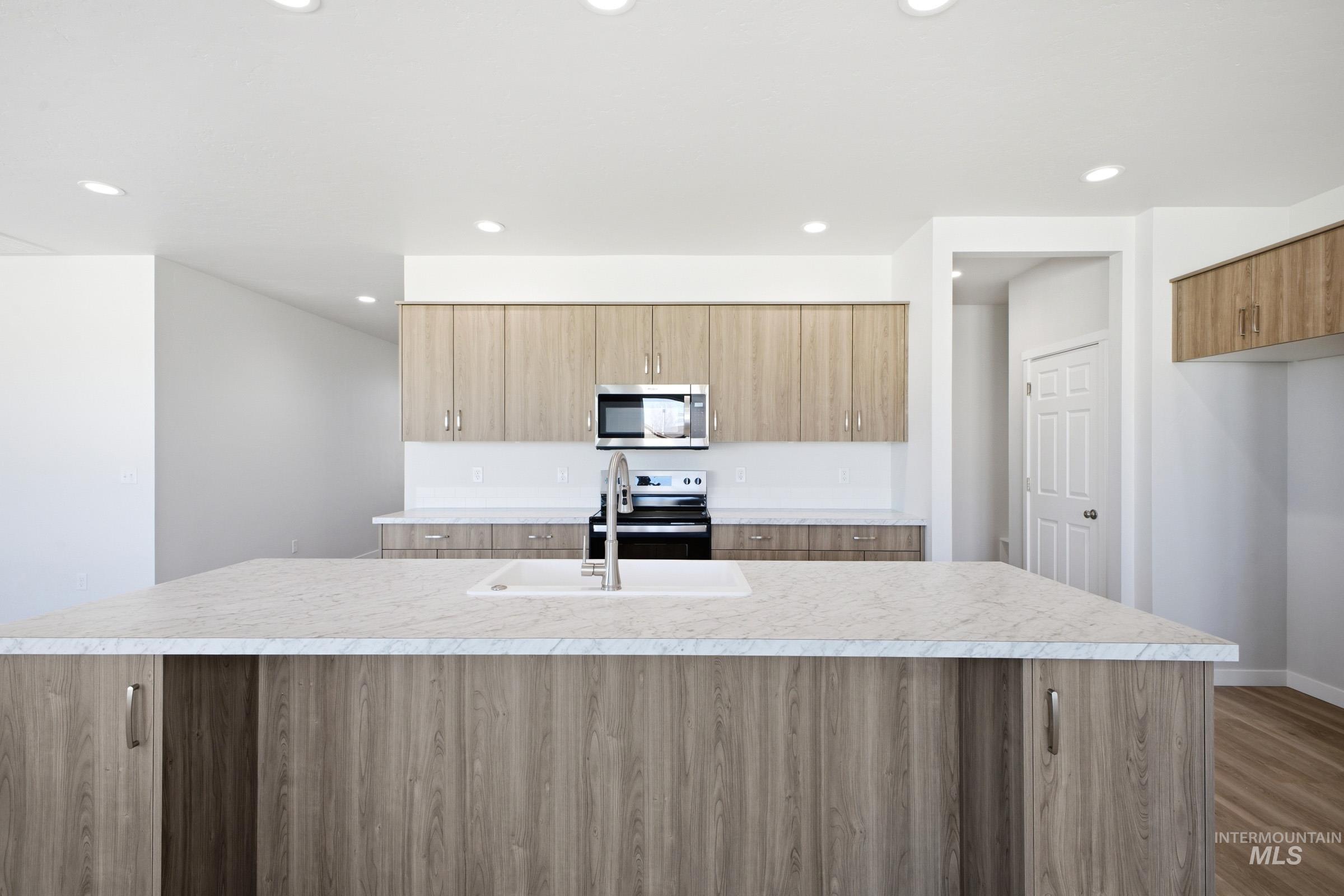 13633 Redway Court Caldwell, ID 83607 - Photo 4 of 29 Kitchen featuring a kitchen island with sink, stainless steel appliances, modern cabinets, dark wood-style flooring, and recessed lighting