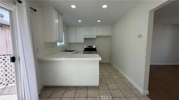 a kitchen with a sink a stove top oven and cabinets