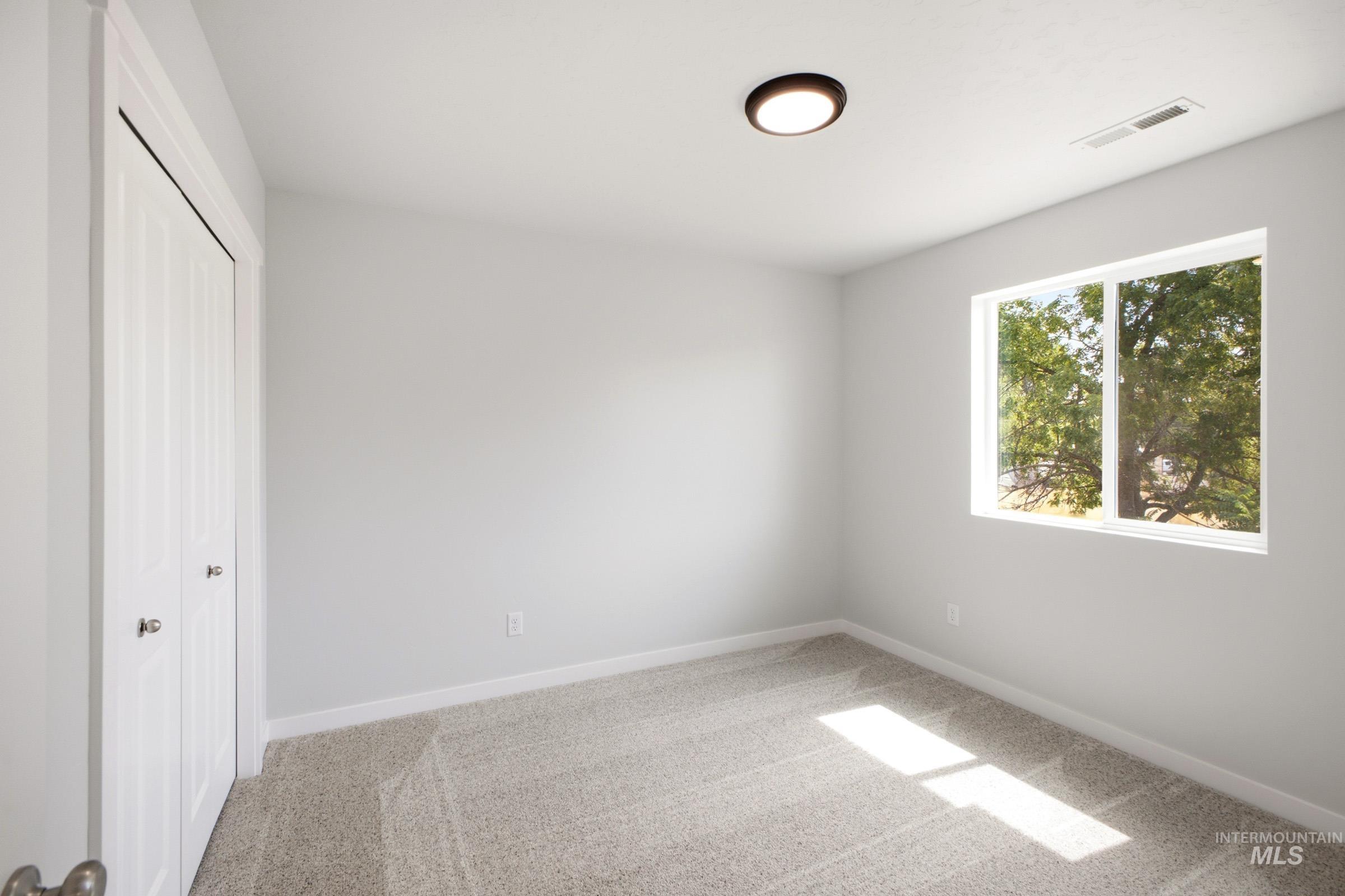 13336 Bank Street Caldwell, ID 83607 - Photo 13 of 24 Neutral tone wall paint, carpeted flooring, flush-mount ceiling light, and a double-panel window