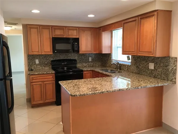 a kitchen with stainless steel appliances granite countertop a stove a sink and a microwave