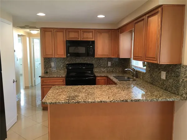 a kitchen with a stove top oven a sink and a refrigerator