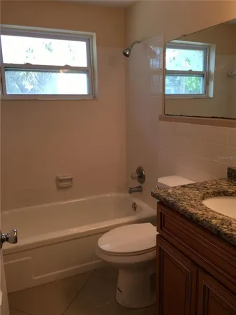 a bathroom with a granite countertop toilet sink and bathtub