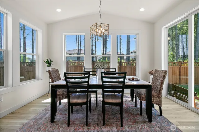 a kitchen with stainless steel appliances granite countertop a dining table chairs sink and cabinets