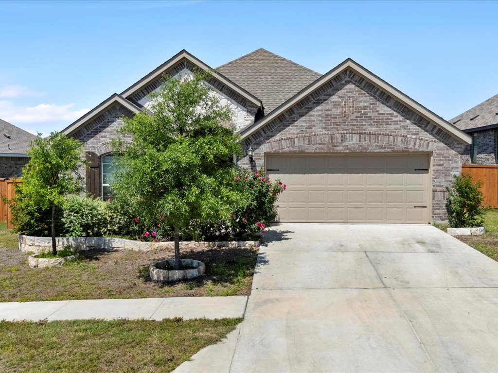 693 Spinnaker Loop Kyle, TX 78640 - Photo 1 of 1 French country home with brick siding, concrete driveway, an attached garage, and a shingled roof