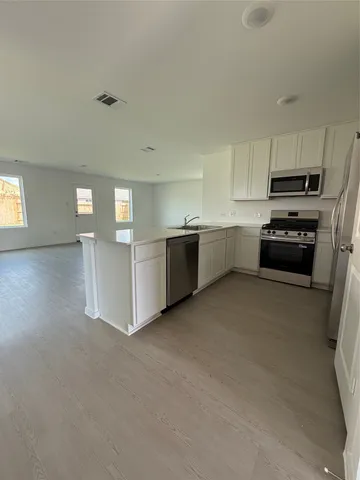 a kitchen with stainless steel appliances a refrigerator sink and stove