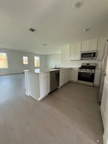 a kitchen with stainless steel appliances a refrigerator sink and stove