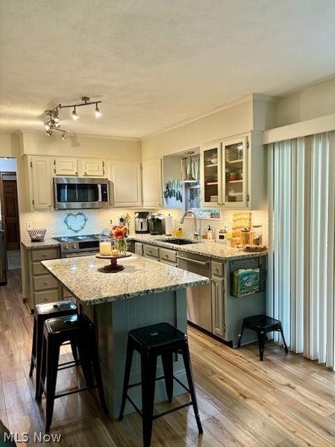 104 Marshall Road Marietta, OH 45750 - Photo 15 of 37 kitchen bar, a kitchen island, stainless steel appliances, white cabinets, and sink