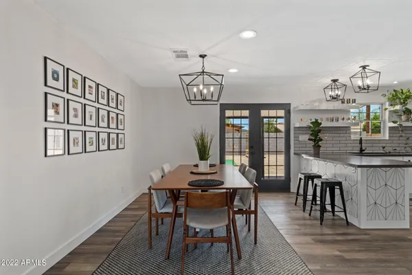 a dining room with furniture a chandelier and wooden floor
