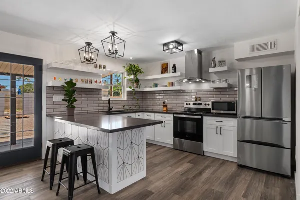 a kitchen with kitchen island stainless steel appliances a counter space a sink and cabinets