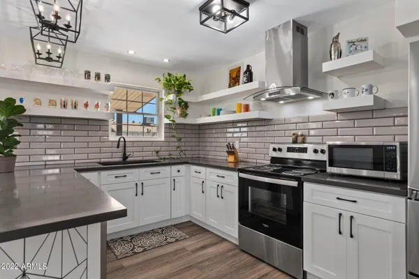 a kitchen with stainless steel appliances granite countertop a stove and a sink