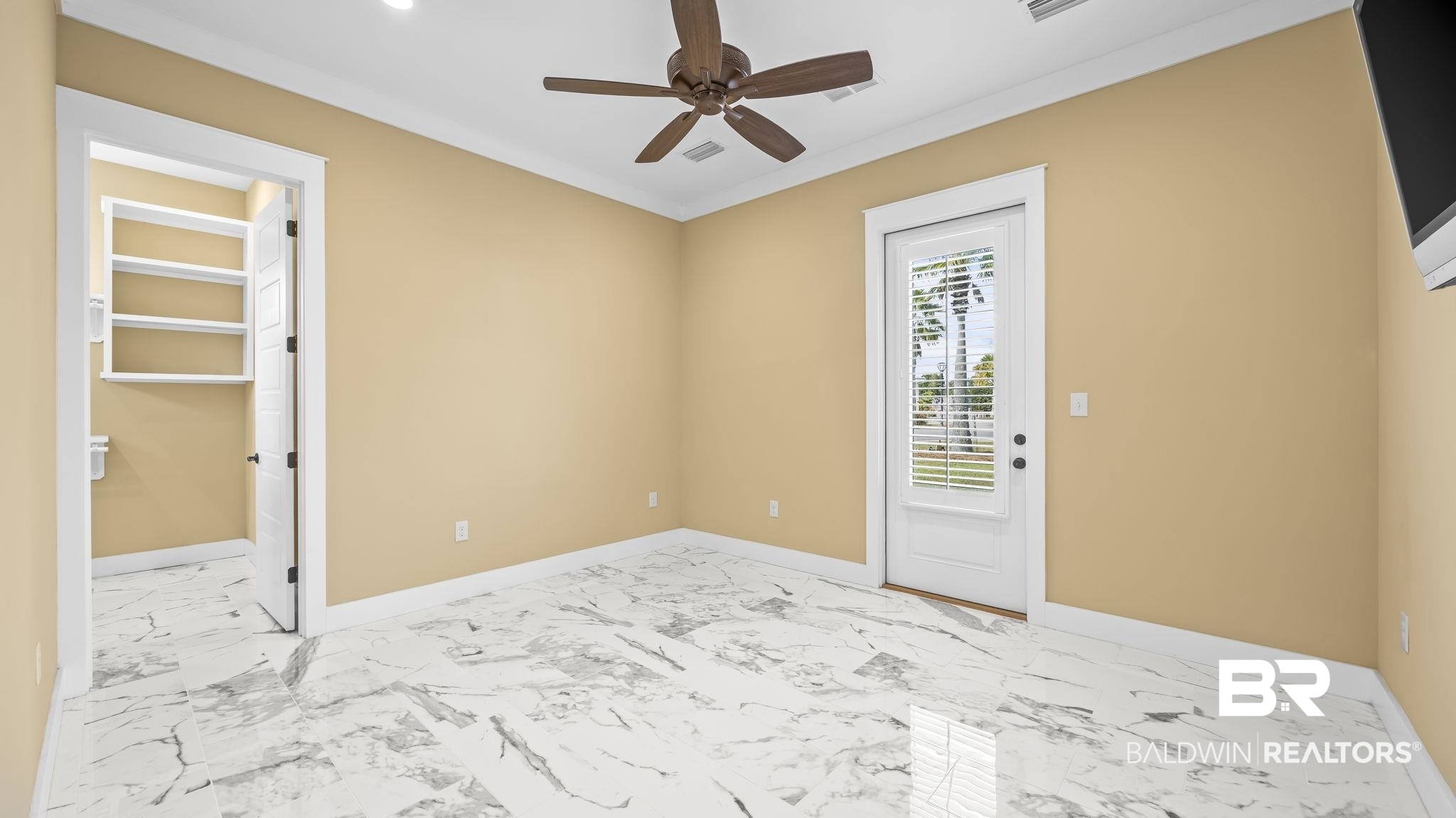 12004 Raptor Court Elberta, AL 36530 - Photo 18 of 57 Empty room with light marble finish floors and a ceiling fan