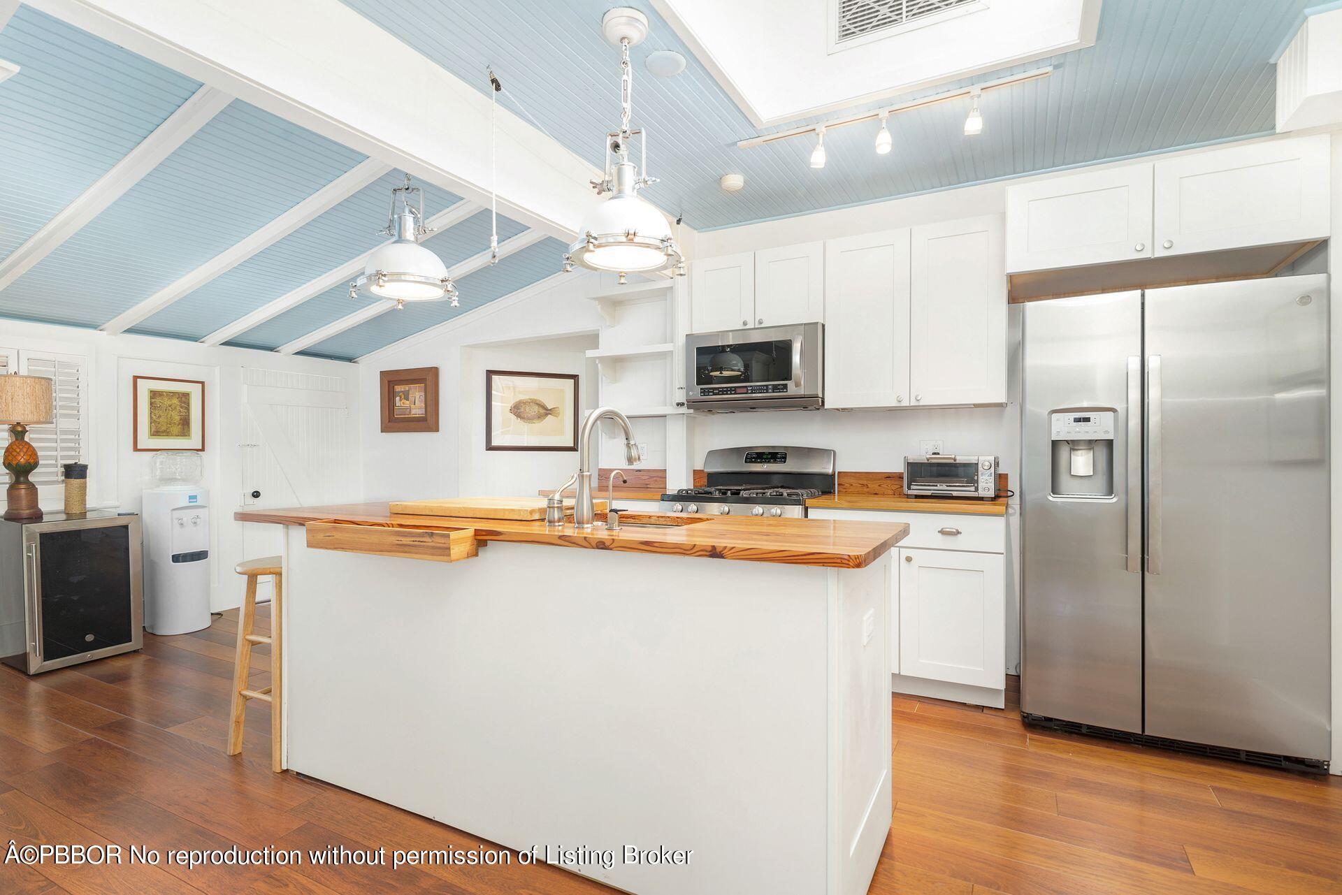138 Root Trail Palm Beach, FL 33480 - Photo 7 of 23 a kitchen with stainless steel appliances a stove refrigerator sink and microwave