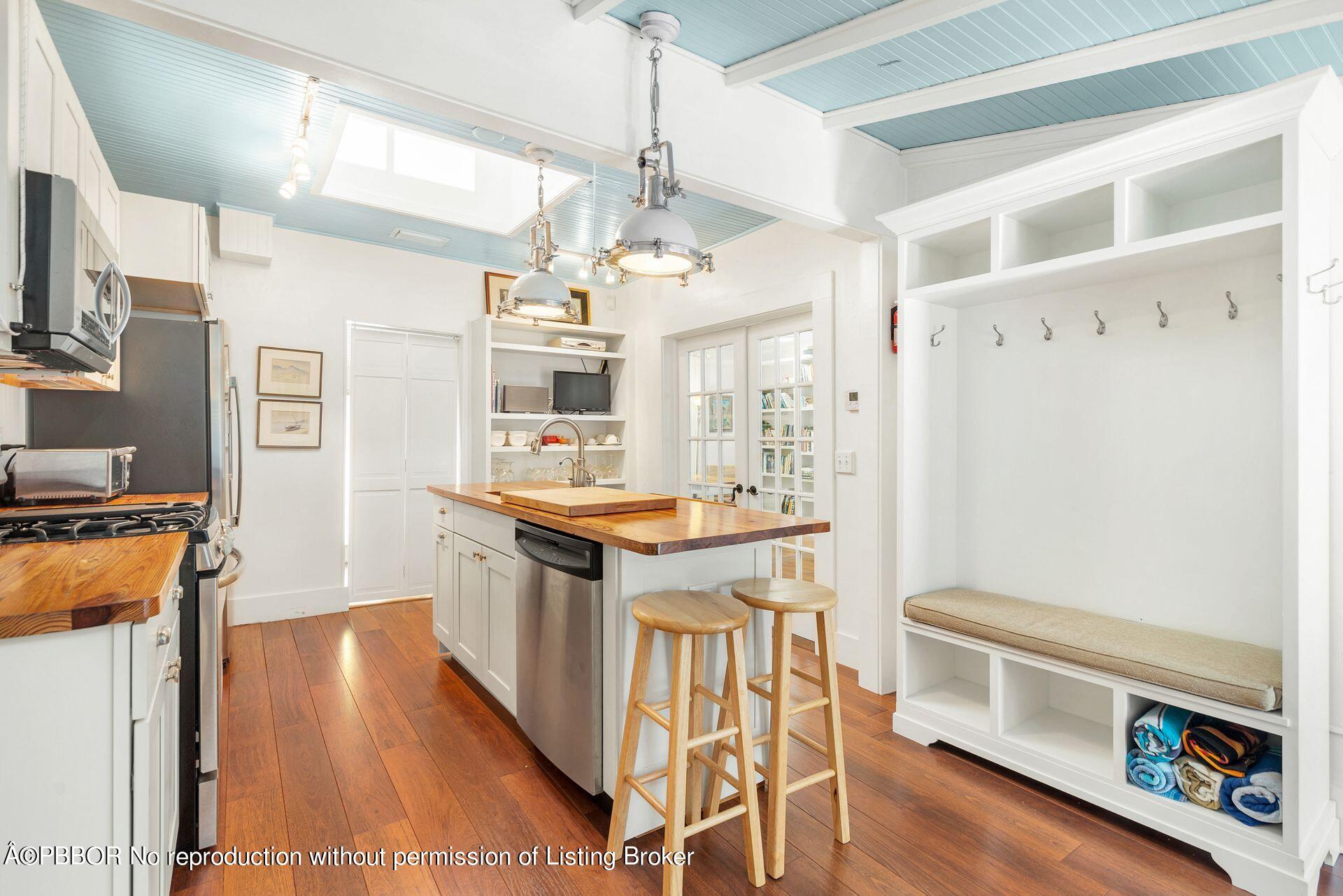 138 Root Trail Palm Beach, FL 33480 - Photo 8 of 23 a kitchen with stainless steel appliances granite countertop a refrigerator a stove a sink dishwasher and white cabinets with wooden floor