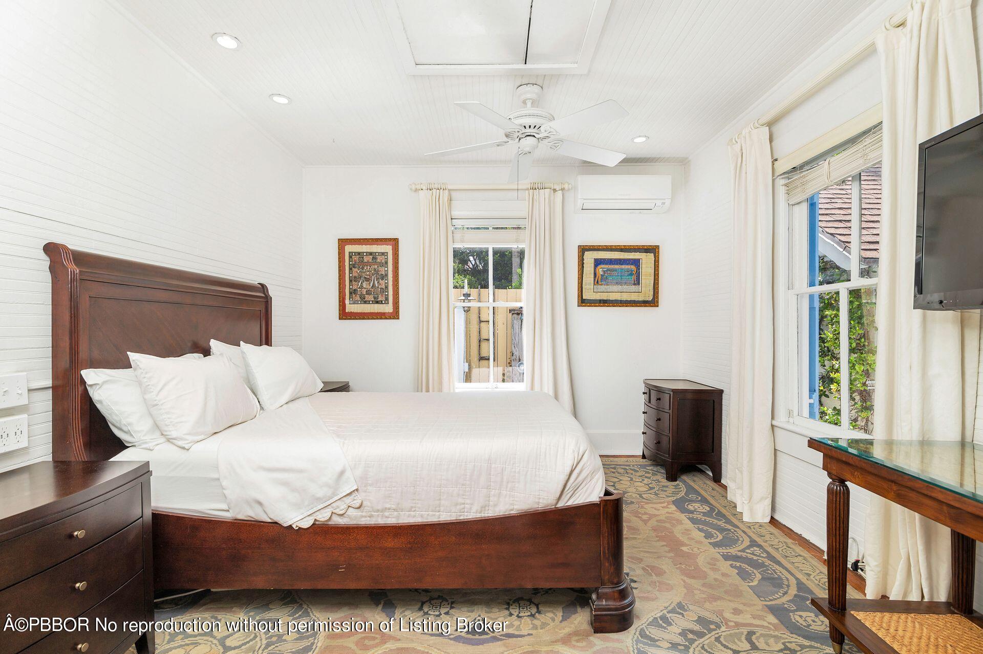 138 Root Trail Palm Beach, FL 33480 - Photo 10 of 23 a bedroom with a large bed and a chandelier