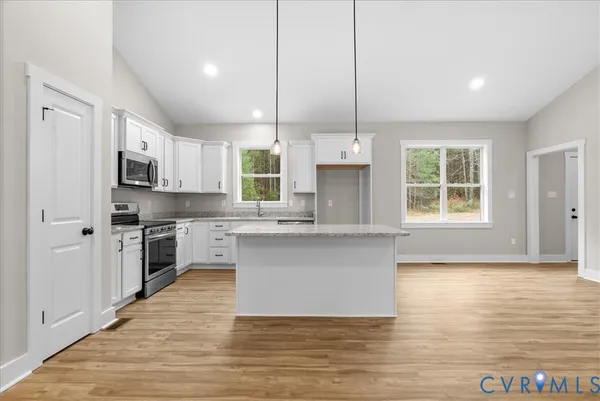 a kitchen with granite countertop a sink window and cabinets